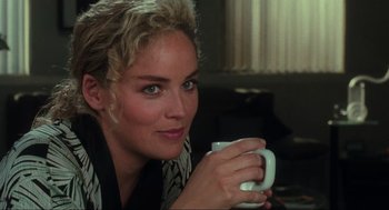 Movie still from “Total Recall” (1990), directed by Paul Verhoeven – A beautiful woman holding a coffee mug in her hands; Close Up shot, Over the shoulder angle