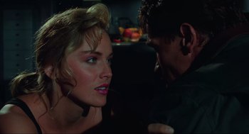 Movie still from “Total Recall” (1990), directed by Paul Verhoeven – A man and a woman in a dark room; Close Up shot, Over the shoulder angle