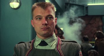 Movie still from “Total Recall” (1990), directed by Paul Verhoeven – A person wearing a uniform; Close Up shot, Low angle