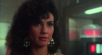 Movie still from “Total Recall” (1990), directed by Paul Verhoeven – A person wearing earrings; Close Up shot, Over the shoulder angle
