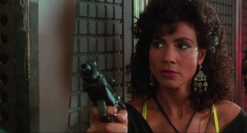 Movie still from “Total Recall” (1990), directed by Paul Verhoeven – A woman is holding a gun up to her face; Close Up shot, Over the shoulder angle