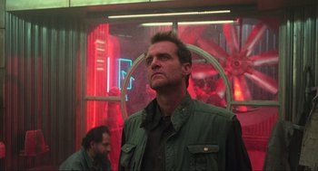 Movie still from “Total Recall” (1990), directed by Paul Verhoeven – A man standing in front of a red wall; Medium shot, Low angle