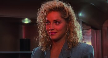 Movie still from “Total Recall” (1990), directed by Paul Verhoeven – A person wearing a suit and tie; Close Up shot, Over the shoulder angle