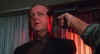 Movie still from “Total Recall” (1990), directed by Paul Verhoeven – A man with a gun in his hand and a gun pointed at his head; Close Up shot, Low angle