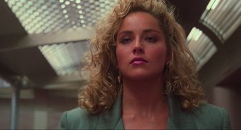 Movie still from “Total Recall” (1990), directed by Paul Verhoeven – A person with curly hair wearing a suit; Close Up shot, Low angle