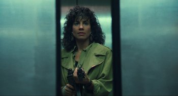 Movie still from “Total Recall” (1990), directed by Paul Verhoeven – A woman holding a gun while standing next to an elevator; Close Up shot, Low angle