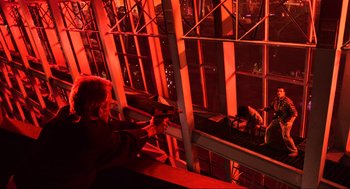 Movie still from “Total Recall” (1990), directed by Paul Verhoeven – A man holding a gun in front of a large window; Extreme Wide shot, Low angle