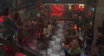 Movie still from “Total Recall” (1990), directed by Paul Verhoeven – A group of people sitting at tables in a room; Wide shot, High angle