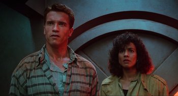 Movie still from “Total Recall” (1990), directed by Paul Verhoeven – A man and a woman standing next to each other; Medium shot, Low angle