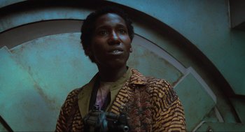 Movie still from “Total Recall” (1990), directed by Paul Verhoeven – A man with a camera standing in front of a wall; Close Up shot, Low angle