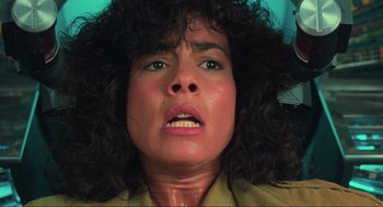 Movie still from “Total Recall” (1990), directed by Paul Verhoeven – A person with curly hair looking at the camera; Close Up shot, Low angle