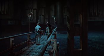 Movie still from “Total Recall” (1990), directed by Paul Verhoeven – A group of people standing on a bridge at night; Wide shot, High angle