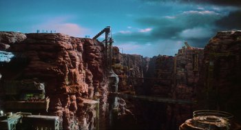 Movie still from “Total Recall” (1990), directed by Paul Verhoeven – A view of a bridge over a river in the middle of a rocky area; Extreme Wide shot, High angle
