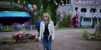 Movie still from “Totally Killer” (2023), directed by Nahnatchka Khan – A woman in a white jacket walking on a dirt road; Wide shot, Over the shoulder angle