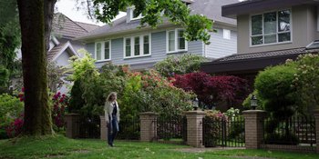 Movie still from “Totally Killer” (2023), directed by Nahnatchka Khan – A woman standing in front of a brick house; Wide shot, Low angle