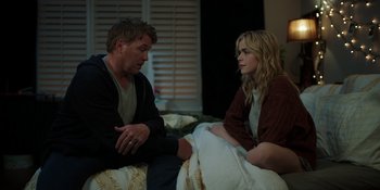 Movie still from “Totally Killer” (2023), directed by Nahnatchka Khan – A man and a woman sitting on a bed talking to each other; Medium shot, High angle