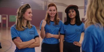 Movie still from “Totally Killer” (2023), directed by Nahnatchka Khan – A group of women standing next to each other wearing blue shirts; Medium shot, Over the shoulder angle