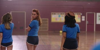 Movie still from “Totally Killer” (2023), directed by Nahnatchka Khan – Two young women are playing a game of tennis; Medium shot, Over the shoulder angle