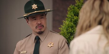 Movie still from “Totally Killer” (2023), directed by Nahnatchka Khan – A man in a sheriff's uniform is talking to a woman; Close Up shot, Over the shoulder angle