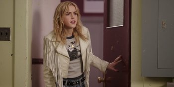 Movie still from “Totally Killer” (2023), directed by Nahnatchka Khan – A woman in a white jacket is standing in front of a door; Medium shot, Over the shoulder angle