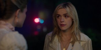 Movie still from “Totally Killer” (2023), directed by Nahnatchka Khan – A young woman is looking at the camera while standing in front of a street light; Close Up shot, Over the shoulder angle