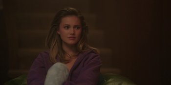 Movie still from “Totally Killer” (2023), directed by Nahnatchka Khan – A beautiful young lady sitting on top of a couch; Close Up shot, Over the shoulder angle