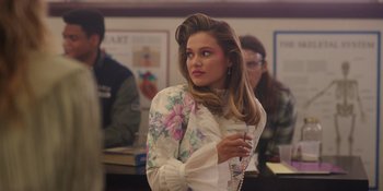 Movie still from “Totally Killer” (2023), directed by Nahnatchka Khan – A beautiful young woman with long brown hair and wearing a white blouse; Medium shot, Over the shoulder angle