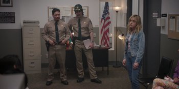Movie still from “Totally Killer” (2023), directed by Nahnatchka Khan – A group of people standing in front of an american flag; Wide shot, Over the shoulder angle