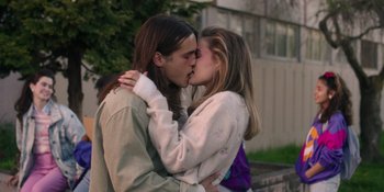 Movie still from “Totally Killer” (2023), directed by Nahnatchka Khan – A man and a woman kissing each other outside; Medium shot, Low angle