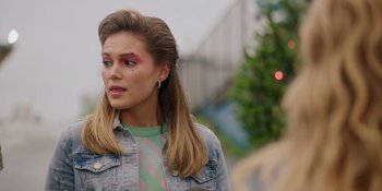 Movie still from “Totally Killer” (2023), directed by Nahnatchka Khan – A young woman with pink eye shadow on her face; Close Up shot, Over the shoulder angle