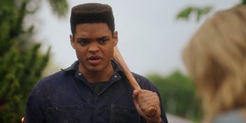 Movie still from “Totally Killer” (2023), directed by Nahnatchka Khan – A young man holding a wooden stick in his mouth; Close Up shot, Low angle