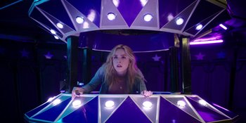 Movie still from “Totally Killer” (2023), directed by Nahnatchka Khan – A woman standing inside of an amusement park ride; Medium shot, Low angle