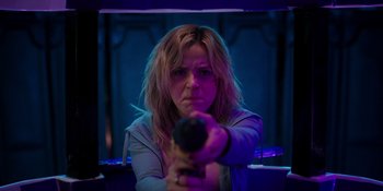 Movie still from “Totally Killer” (2023), directed by Nahnatchka Khan – A woman is holding a gun in a room; Close Up shot, Low angle