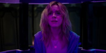 Movie still from “Totally Killer” (2023), directed by Nahnatchka Khan – A woman in a purple light with a scar on her face; Close Up shot, Over the shoulder angle