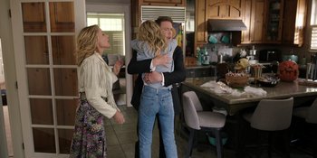 Movie still from “Totally Killer” (2023), directed by Nahnatchka Khan – Two women and a man hugging in a kitchen; Medium shot, Over the shoulder angle