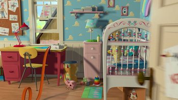 Movie still from “Toy Story” (1995), directed by John Lasseter – A toy story themed room with a crib , desk , chair , and a toy pig; Extreme Wide shot, High angle