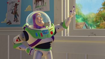 Movie still from “Toy Story” (1995), directed by John Lasseter – A toy story buzz lightyear is holding a cell phone; Medium shot, Low angle