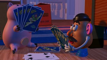 Movie still from “Toy Story” (1995), directed by John Lasseter – A potato head sitting on the floor playing cards; Medium shot, High angle
