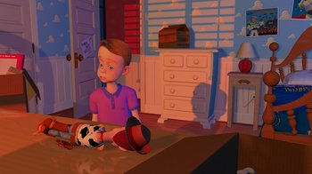 Movie still from “Toy Story” (1995), directed by John Lasseter – A boy sitting on the floor next to a toy cow; Wide shot, High angle