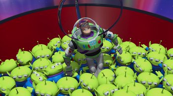 Movie still from “Toy Story” (1995), directed by John Lasseter – A toy story character standing in front of a group of aliens; Extreme Wide shot, High angle