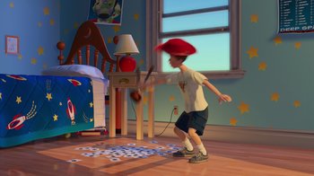 Movie still from “Toy Story 2” (1999), directed by Lee Unkrich – A young boy is playing a video game in his room; Wide shot, High angle