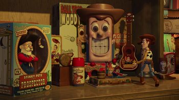 Movie still from “Toy Story 2” (1999), directed by Lee Unkrich – A table with toy story memorabilia and toys on top of it; Medium shot, Over the shoulder angle