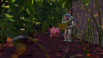 Movie still from “Toy Story 2” (1999), directed by Lee Unkrich – Buzz lightyear and piggy bank in the bushes; Extreme Wide shot, High angle