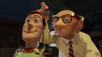 Movie still from “Toy Story 2” (1999), directed by Lee Unkrich – An old man cutting a toy story character's head; Close Up shot, Over the shoulder angle