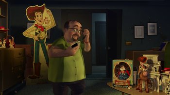 Movie still from “Toy Story 2” (1999), directed by Lee Unkrich – An animated man holding a cell phone in his hand; Medium shot, Over the shoulder angle