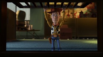 Movie still from “Toy Story 2” (1999), directed by Lee Unkrich – The toy story character woody is standing under a bed; Wide shot, High angle