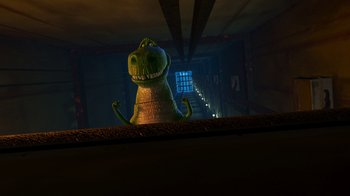Movie still from “Toy Story 2” (1999), directed by Lee Unkrich – A cartoon of a green dinosaur standing on top of a ledge; Extreme Wide shot, Low angle