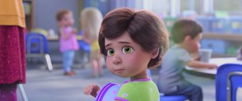 Movie still from “Toy Story 4” (2019), directed by Josh Cooley – A child with big green eyes is looking at the camera; Close Up shot, Over the shoulder angle