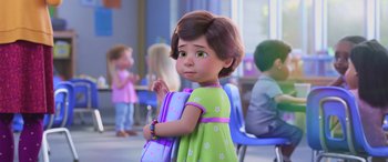 Movie still from “Toy Story 4” (2019), directed by Josh Cooley – A little girl is holding a backpack in a classroom; Medium shot, Over the shoulder angle