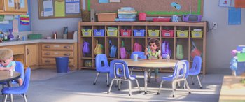 Movie still from “Toy Story 4” (2019), directed by Josh Cooley – A child sitting at a table in front of a bookshelf; Extreme Wide shot, High angle